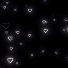 white hearts floating in the air on a black background