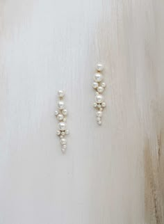 Pearls add a touch of sophistication to any look, and these clustered pearl drop earrings are no exception. Wear these lovely earrings on their own or pair with our matching 2428 necklace! Adorned portion measures approximately 3 1/4 inches long and 3/4 of an inch wide at its widest point Austrian pearls Finished with Bridal Earrings Silver And Pearl, Mixed Metal Wedding Jewelry, Bridesmaid Earrings Dangle, Wedding Pearl Earrings Brides, Bride Pearl Earrings, Pearl Wedding Earrings Brides, Dainty Wedding Jewelry, Pearl Bride Jewelry, Retro Wedding Jewelry