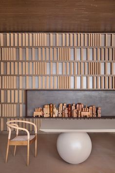 a room with a table, chair and bookshelf on the wall behind it