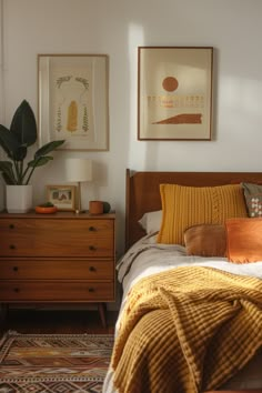 a bed room with a neatly made bed and two pictures on the wall above it