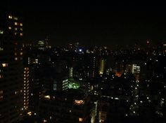 the city is lit up at night with bright lights in the buildings and skyscrapers