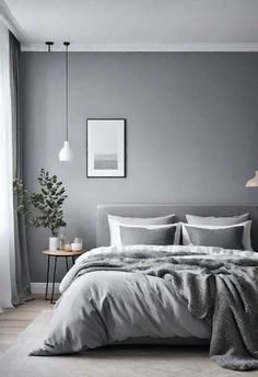 a bedroom with grey walls and white bedding, pillows and blankets on the bed