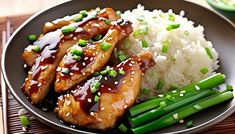 a plate with chicken, rice and asparagus on it next to chopsticks