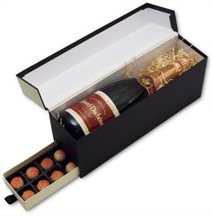 a bottle of wine and some chocolates in a black box on a white background