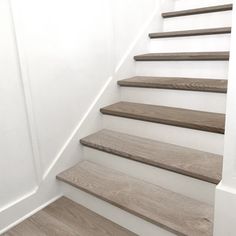 a set of wooden stairs leading up to a white wall