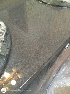 there is a black granite counter top that has been cut off and put on the floor