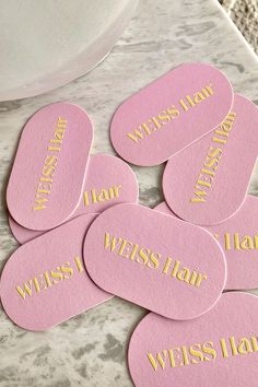 six pink and gold coasters with words on them sitting on a marble counter top