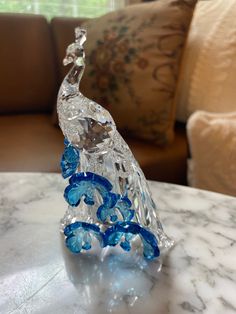 a glass figurine sitting on top of a marble table next to a couch