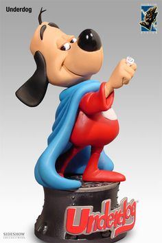 a statue of a cartoon character holding a remote control in his right hand and pointing at the viewer