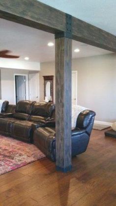 a living room with leather couches and a rug on the floor in front of it