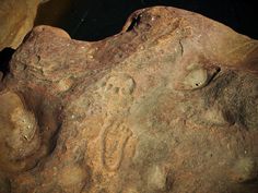 an image of some rocks that are in the water and dirt with small holes on them