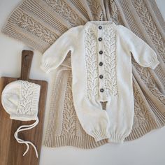 a white knitted sweater and hat next to a cutting board