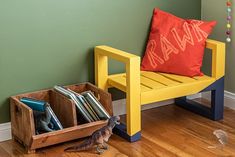 a toy dinosaur next to a yellow chair with books in it