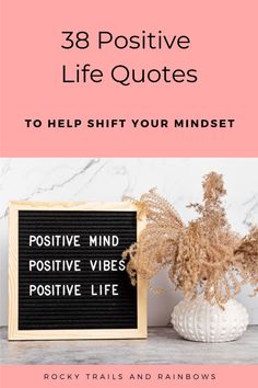 a white vase with flowers and a sign that says, 33 positive life quotes to help you