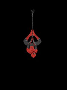 a spider man hanging upside down in the dark with his hands on his hipss