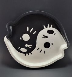 a black and white bowl with a cat on it's face in the shape of a skull