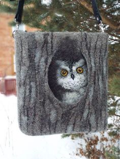 an owl in a tree stump with yellow eyes hanging from it's back end