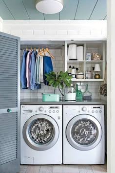 a washer and dryer sitting in front of a shelf with clothes on it