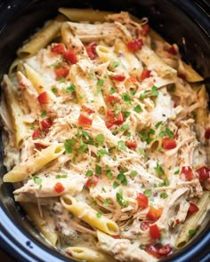 a crock pot filled with pasta and chicken