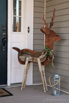 a wooden deer statue sitting on the front porch