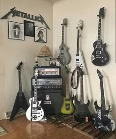 guitars and amps are lined up against the wall in a room with white walls