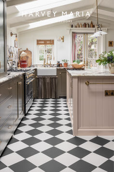 a kitchen with black and white checkered flooring next to a stove top oven