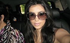 a woman wearing sunglasses sitting in the back seat of a car