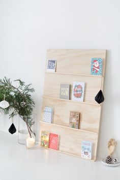 there is a wooden shelf with pictures on it and a potted plant next to it