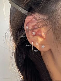 an ear piercing is shown with three small stars on the top and bottom of it