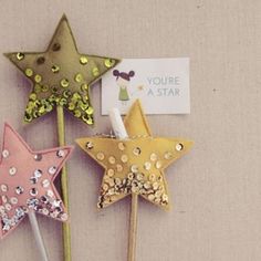 three star shaped hair pins with glitter on them, one gold and the other pink