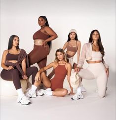 the women are posing together in their sports bras and leggings, all wearing matching outfits