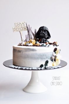 a star wars themed birthday cake with a darth vader topper