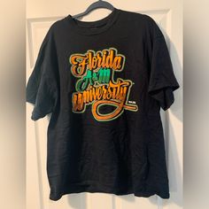 Show Off Your Love For Florida A&M University With This Stylish Famu Rattlers T-Shirt. This Black Cotton Blend Shirt Features A Striped Pattern, Short Sleeves, And A Crew Neckline. The Shirt Also Includes The Famu Logo As An Accent, Adding A Touch Of School Spirit To Your Outfit. Perfect For College Football Season Or Just A Casual Day Out, This Vintage Shirt Is A Must-Have For Any Famu Fan. With Its Regular Fit And Size Xl, It's Suitable For Men Of All Sizes. Don't Miss Out On The Chance To Rep Famu Tshirts, Famu Rattlers, College Football Season, Workwear Shorts, Grey Trench Coat, Teal Top, Harley Davidson Shirt, Compression Pants, Striped Hoodie