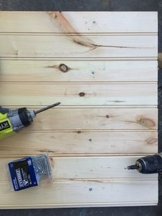 two drillers are on top of a piece of wood and one is holding a screwdriver