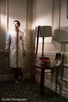 a man standing next to a lamp in a room