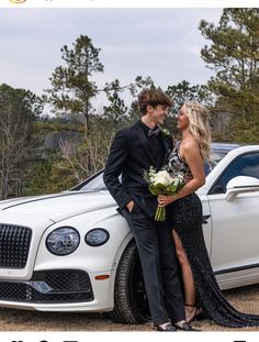 a man and woman standing next to a white car