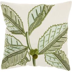 a white pillow with green leaves on it