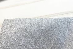 a piece of silver glittered paper with writing on it