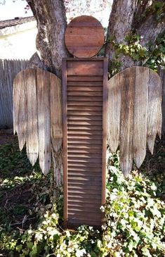 an angel's wing is sitting in the grass next to a tree and fence