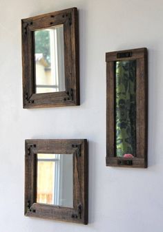 two mirrors mounted to the side of a wall next to each other on a wall