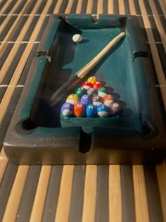 a pool table with billiards and cues in it, on top of a bamboo mat