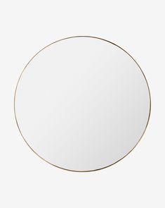 a round white mirror with gold trim around the edges, on a white wall background