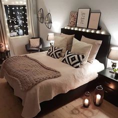 a bedroom with lights on the wall and a large bed in front of a window