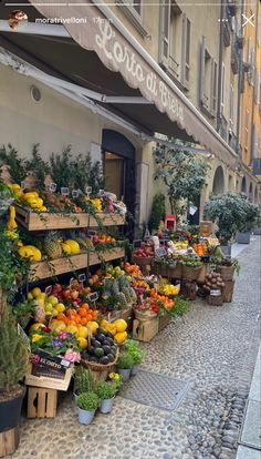 an outdoor market with lots of fresh fruits and veggies for sale on the sidewalk