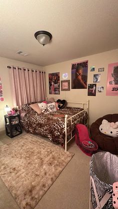 a bedroom with two beds, pink curtains and pictures on the wall above them is decorated in leopard print