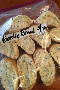 garlic bread slices wrapped in plastic on top of a wooden table with a price tag