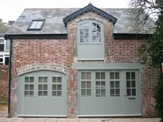 a brick house with two garage doors and windows