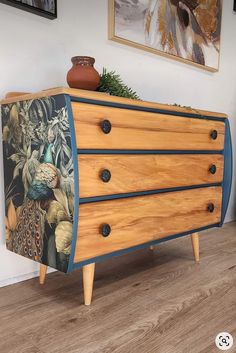 a wooden dresser with peacocks painted on it