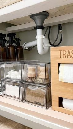 the shelves in this bathroom are organized with clear bins for towels and toiletries