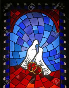 two white doves with rings in their beaks on a stained glass window stock photo